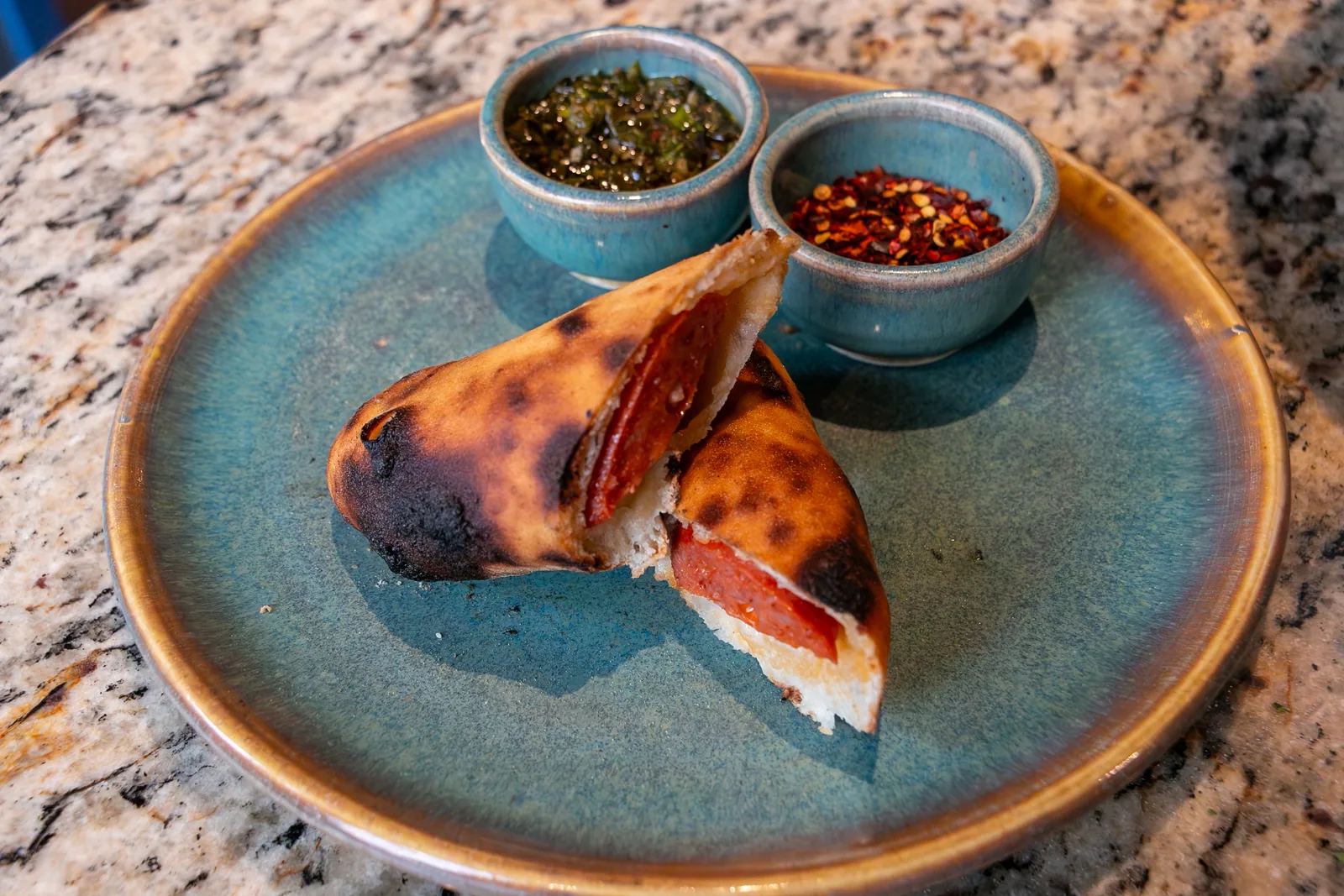 Bollo Preñado partido, servido con salsas en plato de cerámica