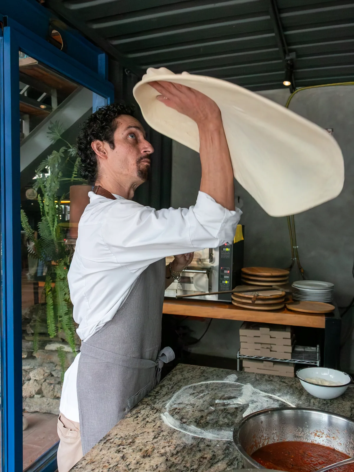 El pizzaiolo de Salvo lanzando la masa al aire en la cocina de Barrio 28